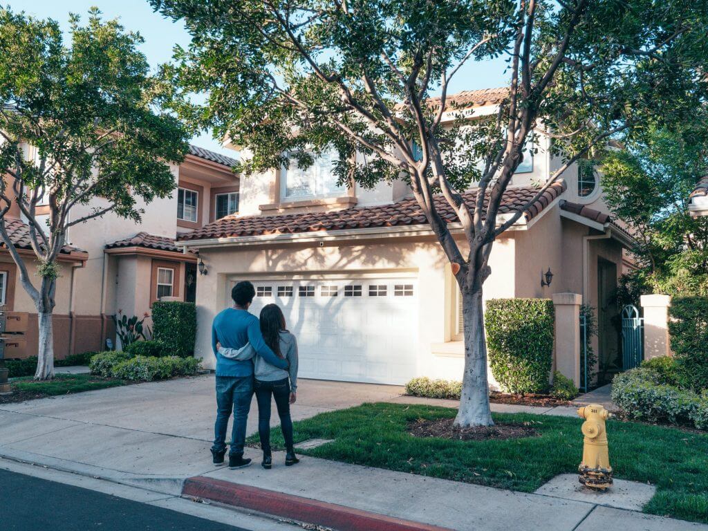 couple looking at exterior of house