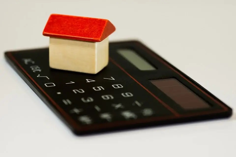 small toy house on top of calculator