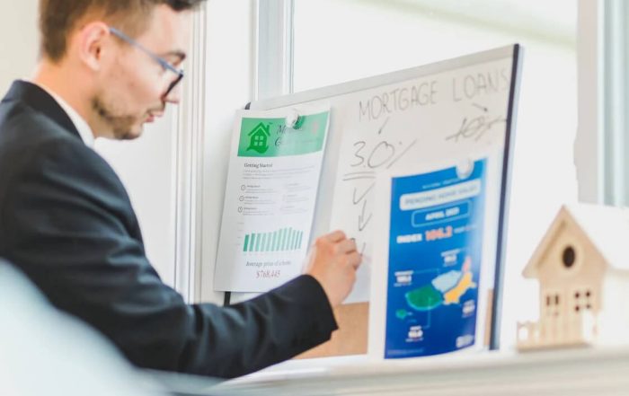 man writing real estate investment plans on whiteboard