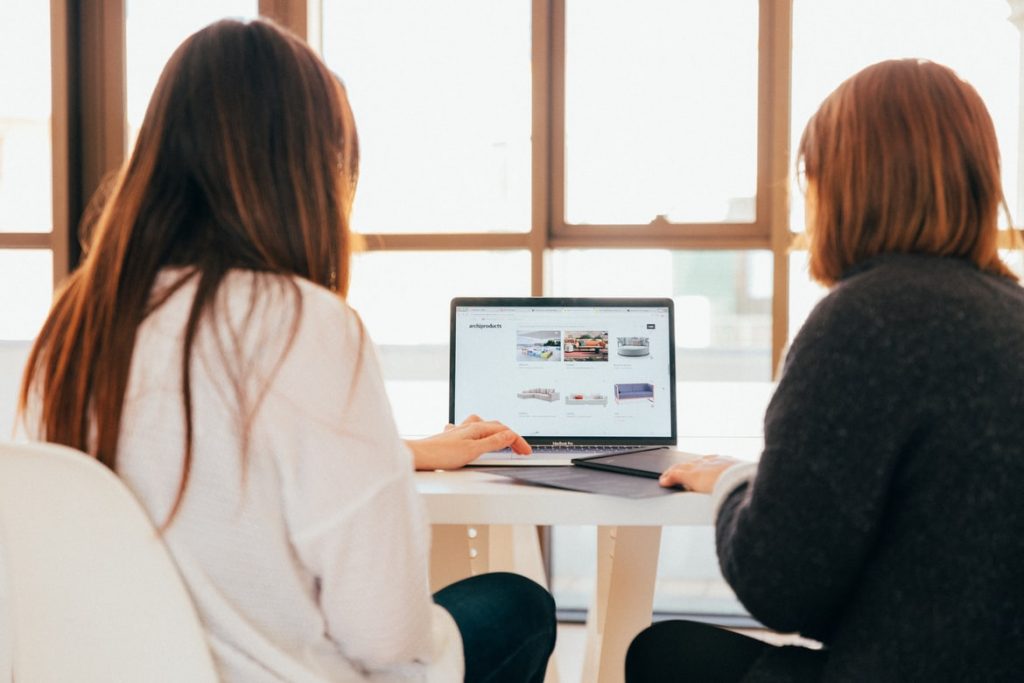 two woman looking at laptop