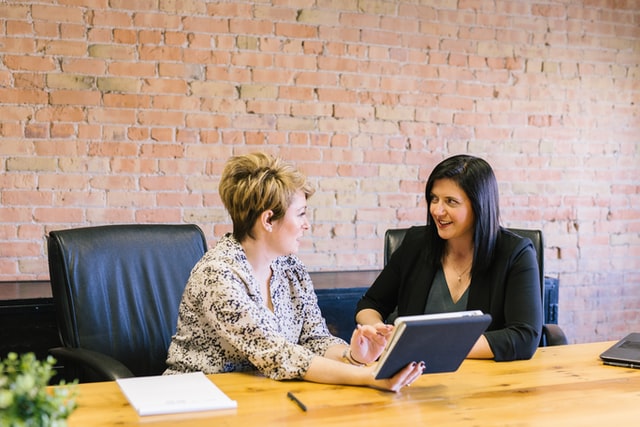 two woman sitting on leather chairs